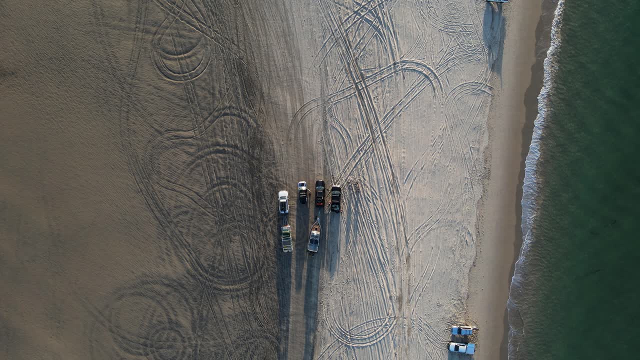 파도가 해안선을 덮치는 해변에 주차된 4wd 차량