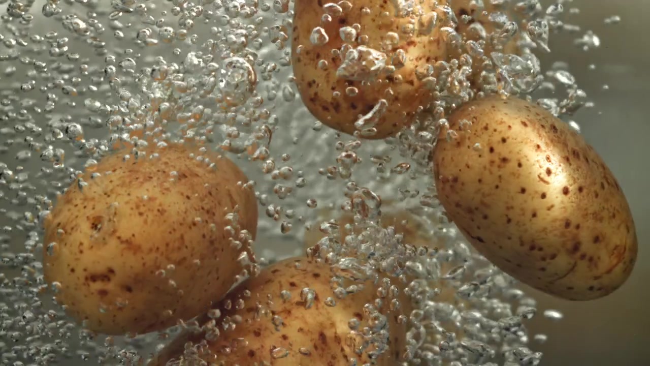 Patate fresche immerse in acqua bollente con bollicine effervescenti