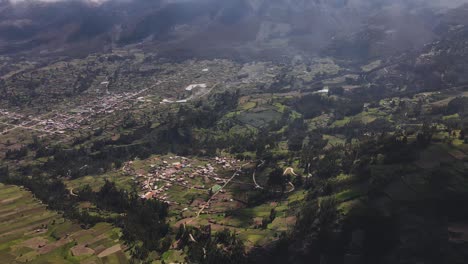 Aufschlussreiche-Drohnenaufnahme-Des-Schneebedeckten-Huascaran-Gipfels,-Der-Mit-Wolken-Bedeckt-Ist,-Neben-Einem-Riesigen-Grünen-Tal-In-Den-Anden-Von-Peru