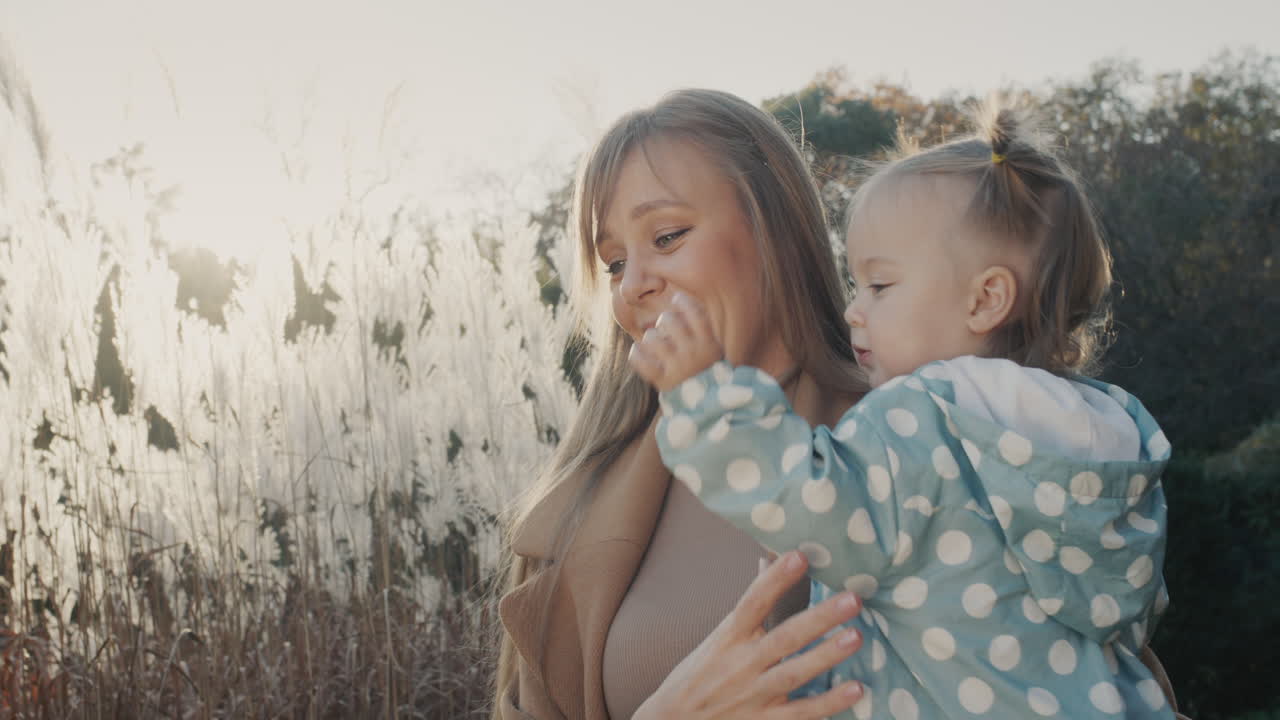 retrato de una madre joven feliz con su pequeña hija. juntos en un paseo por el parque de otoño