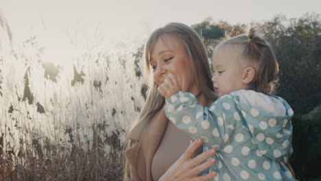 Portrait-of-a-happy-young-mother-with-her-little-daughter.-Together-on-a-walk-in-the-autumn-park