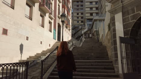 woman walking up stairs in city