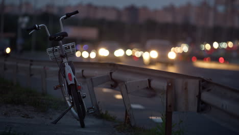 bicycle standing city street at road guardrail. rental town transportation.