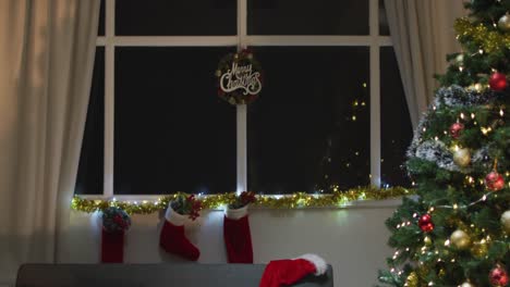 video of christmas greetings, decorations, christmas tree, lights and christmas stockings at home