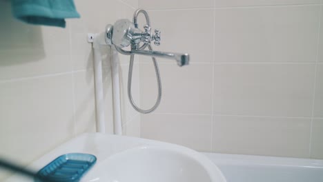 faucet and shower over bathtub near white sink in bathroom