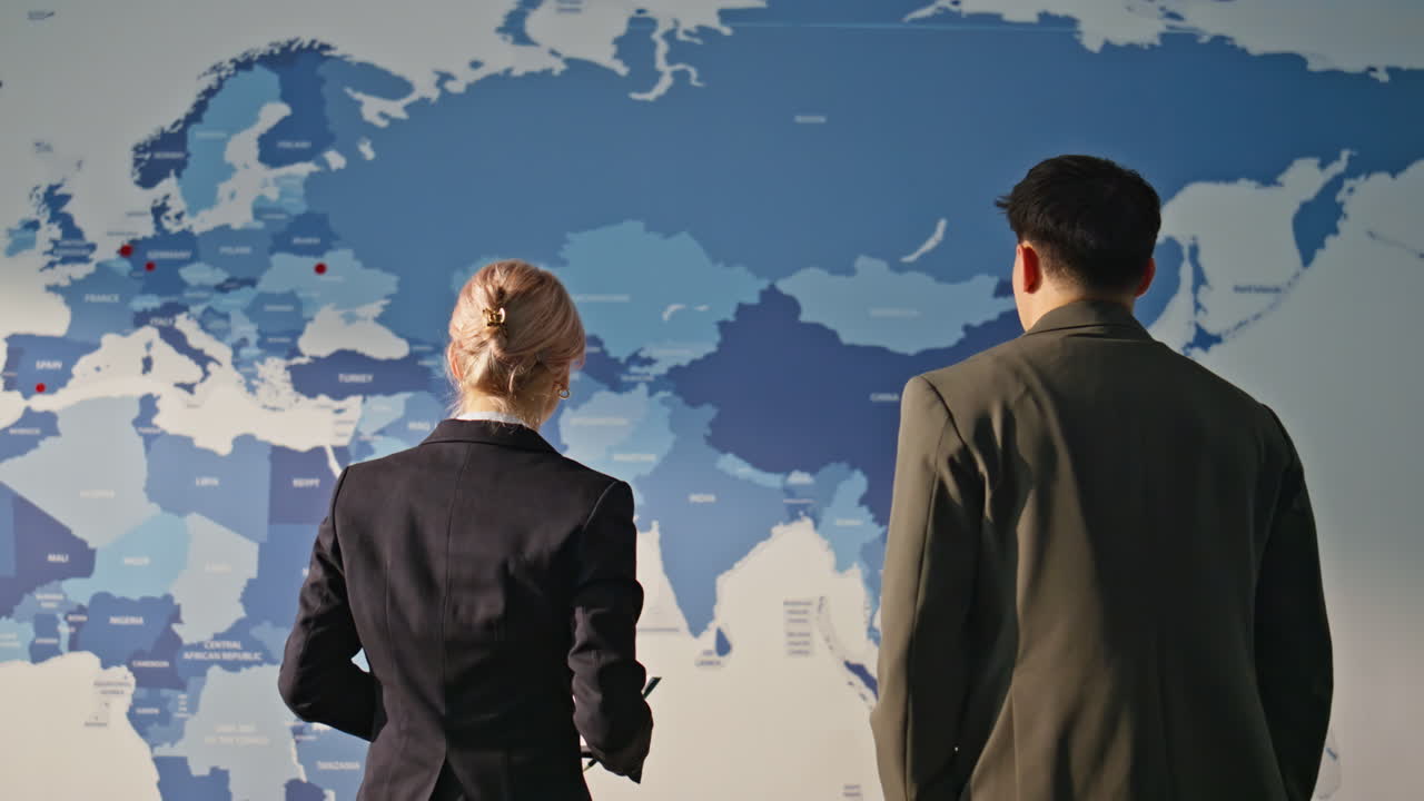 Businesspeople discussing global economy watching estimating map. Two colleagues