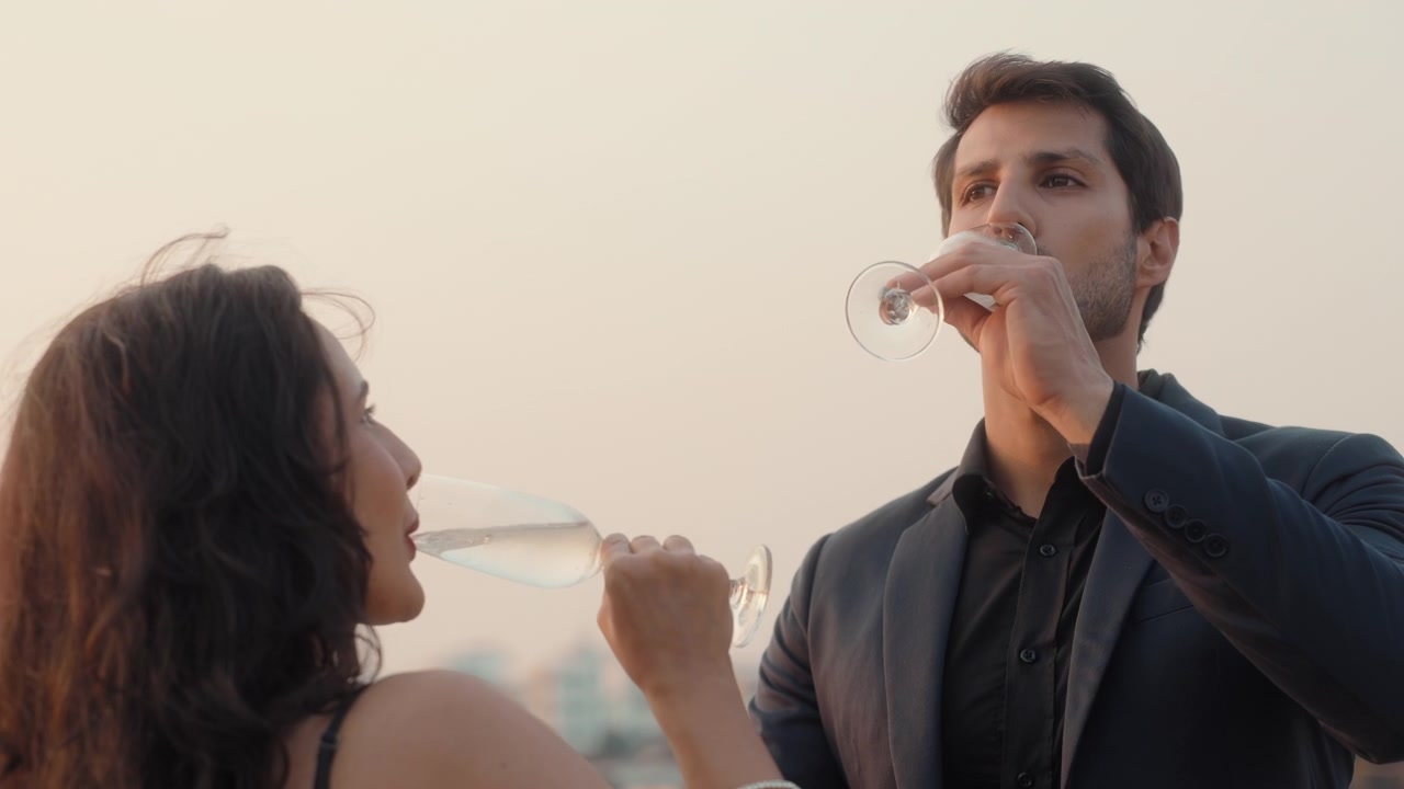 Coppia elegante che beve champagne e brinda su una terrazza panoramica