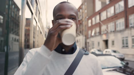 african american businessman walking through city using smart phone