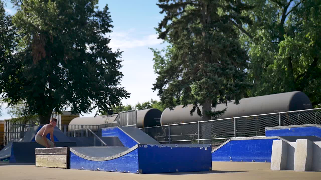 Skater does a 360 off of a wavy ledge