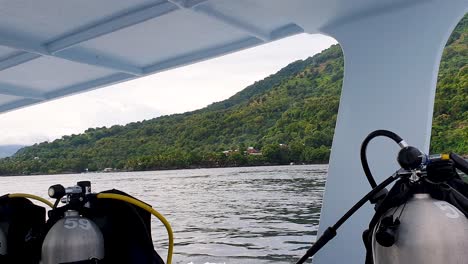 a bordo de un barco de buceo con tanques de aire de oxígeno y vista de la isla tropical y el océano en la isla de alor en las islas sunda menor de east nusa tenggara, indonesia