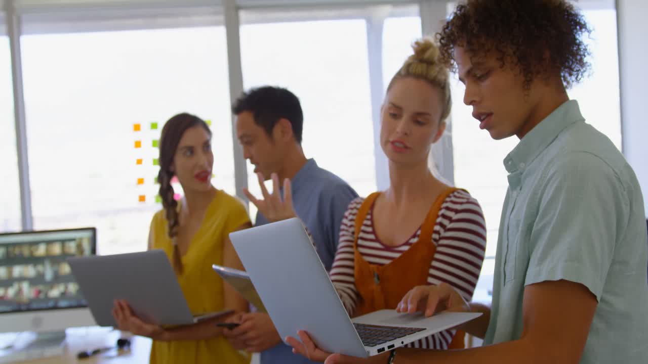 colegas de negocios multiétnicos discutiendo y trabajando en computadoras portátiles y tabletas digitales en el moderno off