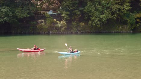 Diaaufnahme-Von-Menschen,-Die-In-Kyoto,-Japan,-Einen-Fluss-Hinunter-Kajak-Fahren-4k-Zeitlupe