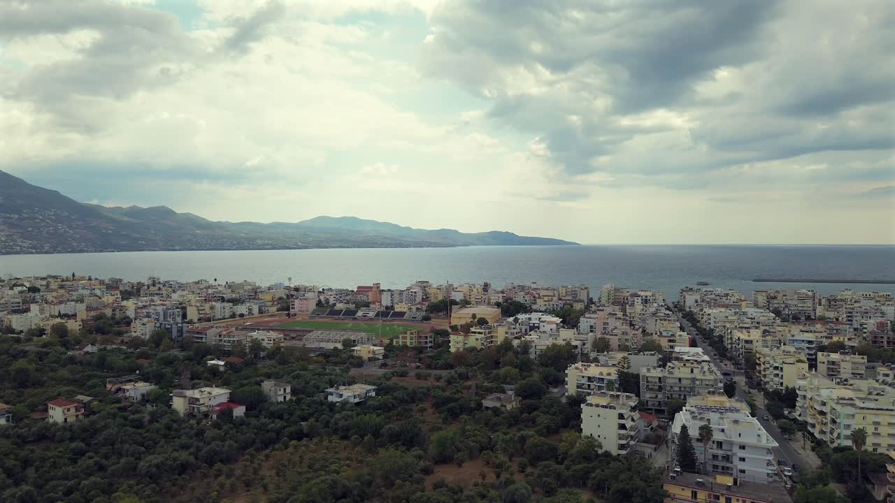 Aerial high angle view of Messinian gulf as seen from Kalamata city, Peloponnese , Greece. Orbital, raise up drone movement, cloudy autumn day 4k footage