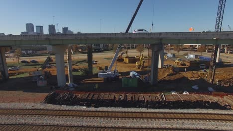 Cars-drive-over-busy-city-overpass-and-equipment-during-on-ramp-construction-project