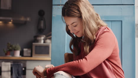mujer hermosa usando tecnología de reloj inteligente en casa en la cocina