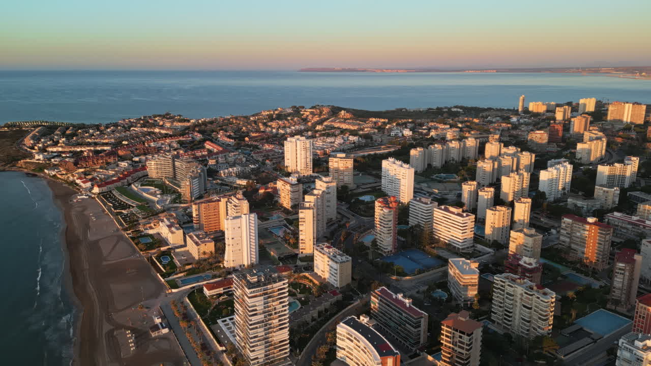 Aerial drone view of the Mediterranean Sea and the city of Alicante, Spain at sunset