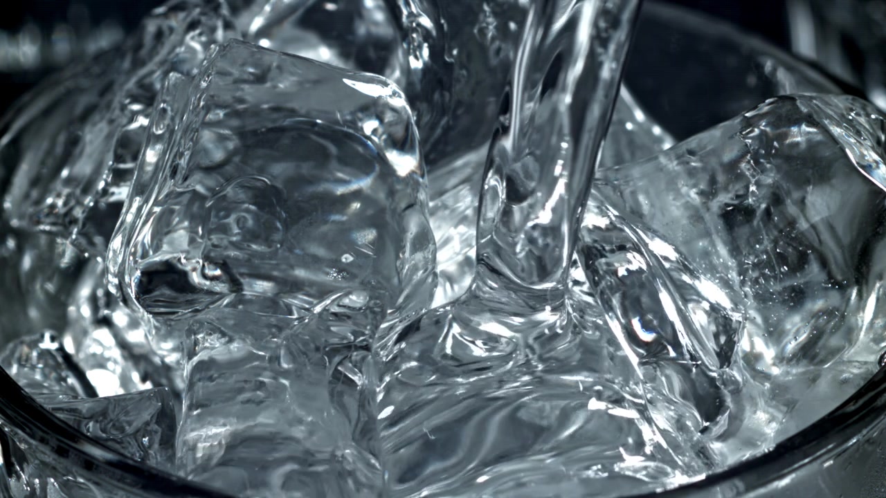 Slow Motion Water Pouring into a Glass of Ice