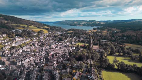 aerial footage of the quite village of ambleside showing st mary’s church and lake windermere in the distance