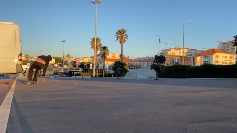 An-excited-man-carves-up-the-skate-park-on-a-summer-day,-as-a-cheerful-male-skateboarder-in-a-hood-practices-professional-tricks