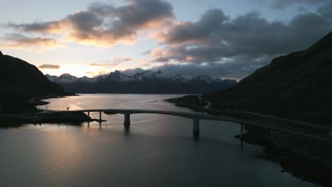 bridge over sundklakkstraumen in norway during twilight, mountains in backdrop, serene dusk sky