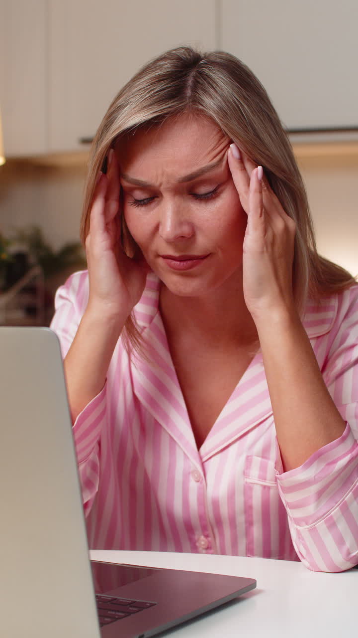 Libera professionista adulta con il laptop si massaggia la tempia, si prende una pausa, chiude gli occhi, stress, mal di testa dopo il lavoro