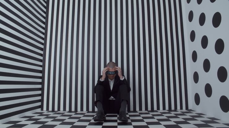 Uomo d'affari depresso in una stanza con illusione ottica