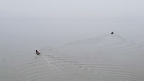 Aerial-over-small-wooden-trawler-boats-heading-out-to-sea,-Indian-ocean---Bay-of-bengal