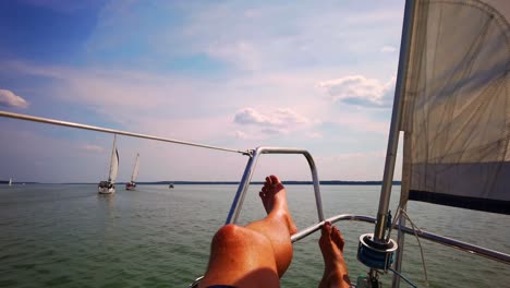 Close-Up-Shot-Relaxed-Traveler-Man-Legs-on-Motorboat-on-Beautiful-Island-and-Mountain-Carefree-Concept