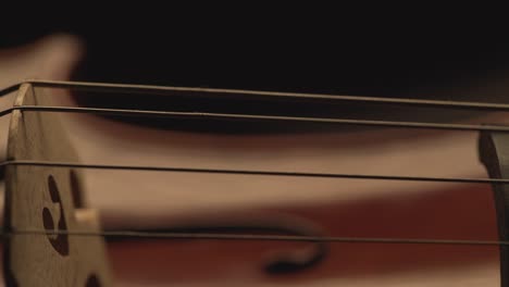 macro primer plano del violonchelo, el arco del violoncelo, la interpretación del violoncho y el pulso de las cuerdas, el video musical, el violonchelista