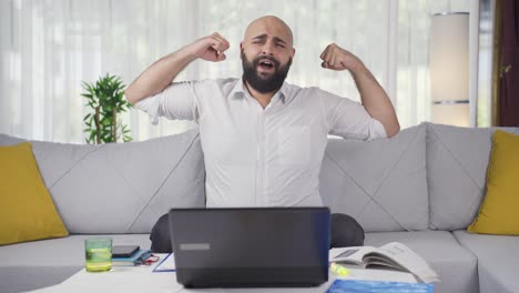 Home-office-worker-man-yawns-and-relaxes-at-the-camera.