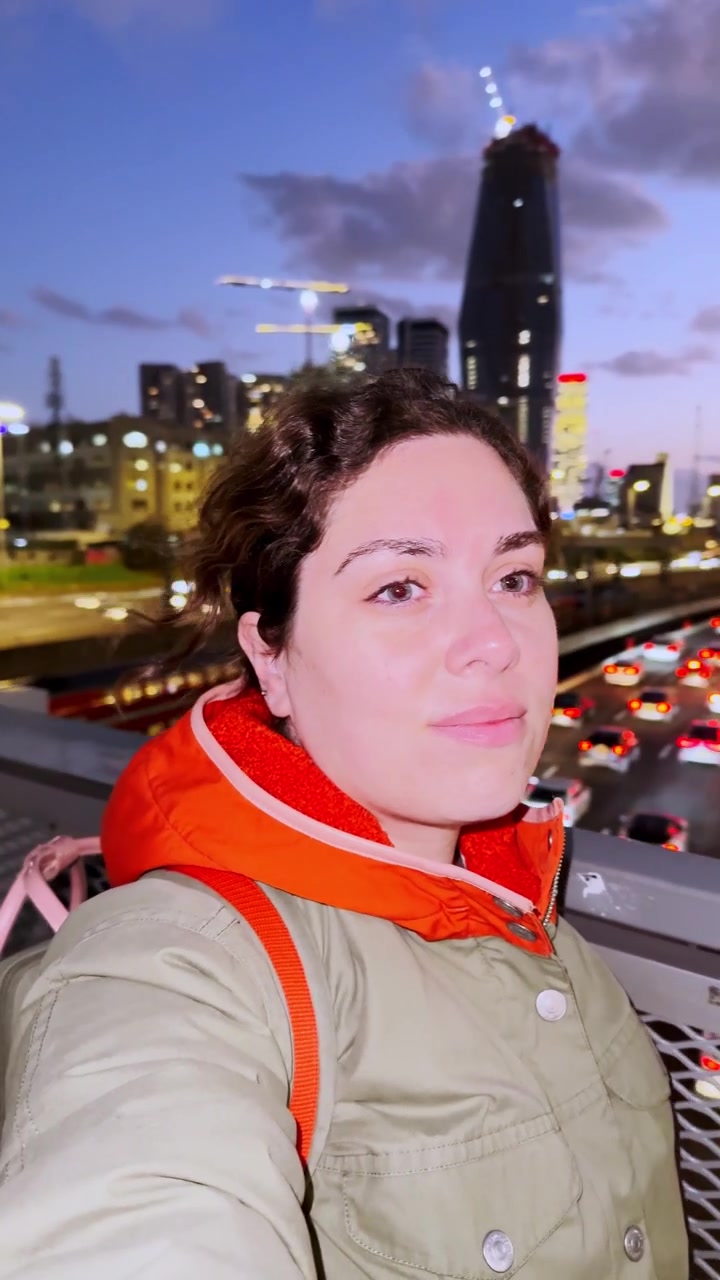 Giovane donna che si gode la vista della città al tramonto.