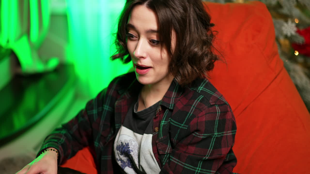 Cat-lover lady sits in chair with her lovely pet. Black yellow-eyed cat tries to escape.