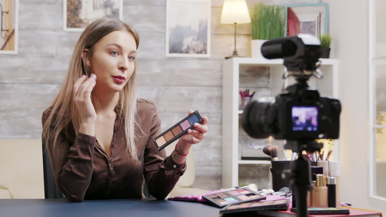 Woman presenting a makeup palette in front of a camera