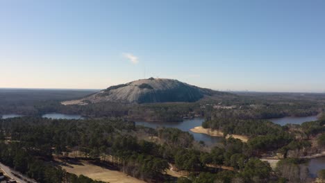 aerial drone shot slowly rotating counter clockwise around the nw side of stone mountain in stone mountain park near atlanta with the confederate memorial in the shadows