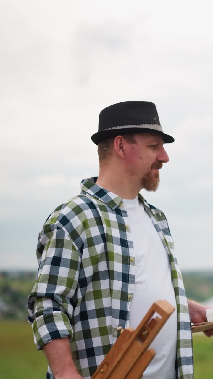 한 남녀가 잔디에서 걸어서 대화를 나누고 있다. 모자를 쓰고 색 카드본 상자를 들고 있는 남자는 색 드레스와 모자를 입은 여자와 대화를 나다.