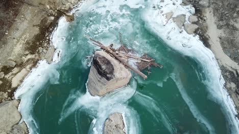 Driftwood-Caught-on-River-Boulder