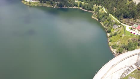 aerial shot starting on a large dam then revealing a seaside mountain village