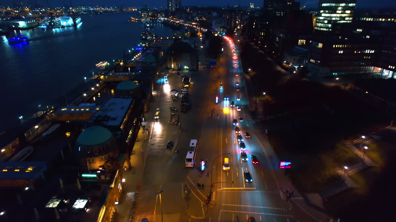 Luftdronebilde av Hamburg om kvelden, Tyskland. Elbe-kystlinjen, fortøyde båter, havn, klassiske og moderne bygninger, veier med biler og nattlys