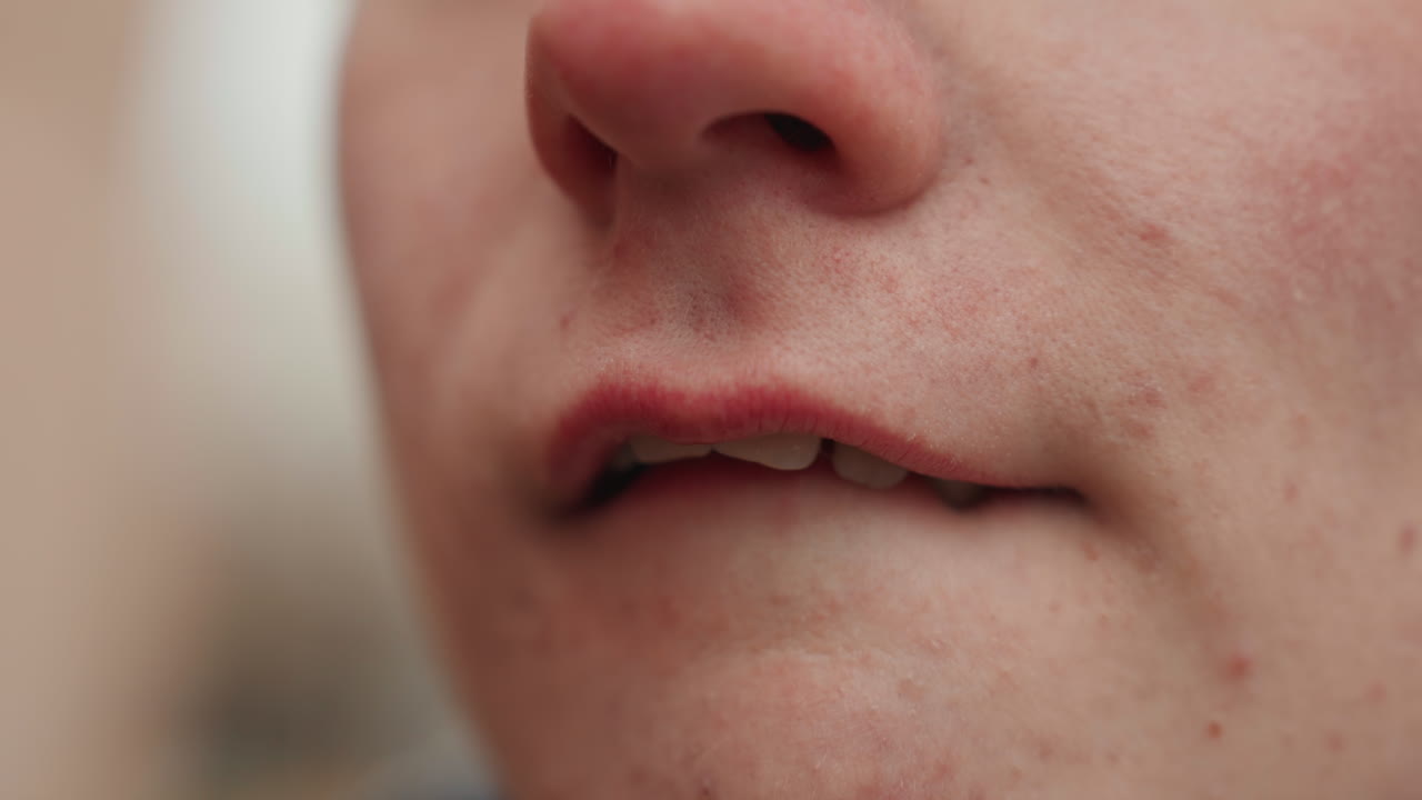 Micro-momenti espressivi delle labbra di un creatore bianco, prova di un doppiatore e narratore silenzioso, sottili movimenti della lingua e delle labbra, studio ravvicinato della bocca che rivela texture ed emozione, sfondo urbano spontaneo, attenuato.