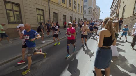 runners on street at stockholm marathon on sunny day as spectators cheer them on