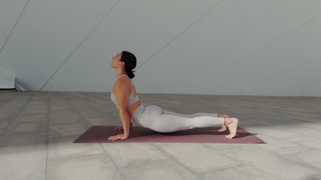 mujer realizando una secuencia de yoga al aire libre: adho mukha svanasana, chaturanga, urdhva mukha svanosana