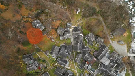 drone recuando para cima e inclinando para mostrar o resto da casa de pedra na aldeia de cavergno, no distrito de vallemaggia, cantão de ticino, na suíça