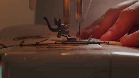 Side-view-close-up-of-sewing-machine-foot-and-needle-passing-through-fabric