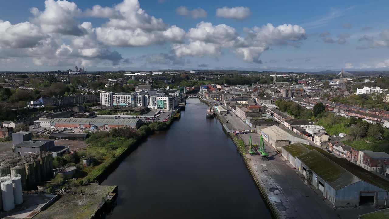 Drogheda, County Louth, Ireland, April 2023. Drone pulls backwards over the Boyne Viaduct railway bridge with the city in the background under a warm blue sky.
