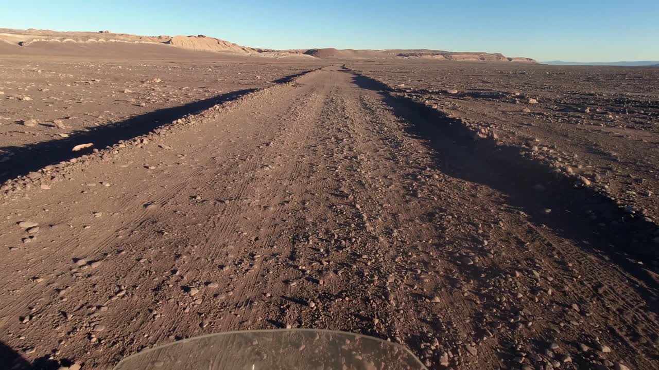 pov mientras conduce en motocicleta por un camino de tierra accidentado en el desierto de atakama, chile