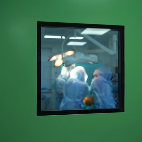 surgery in the operating room. teamwork of doctors in blue uniform doing an operation. view through the window from the corridor.