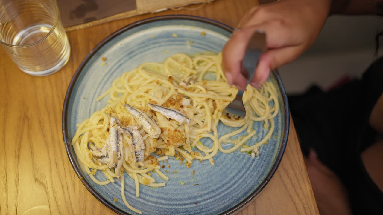 Woman Using The Fork To Eat Anchovies Spaghetti For Dinner
