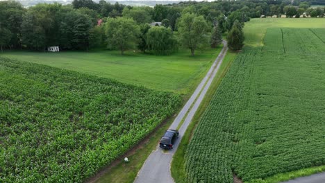 black suv entering farm lane in rural usa