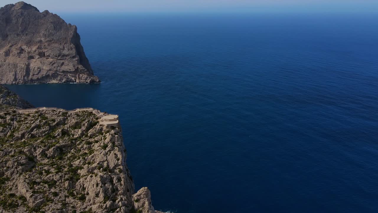 Explore the breathtaking panoramic views from Mirador es Colomer in Pollensa, Mallorca, capturing the serene beauty of the Mediterranean coast and surrounding cliffs at sunset.