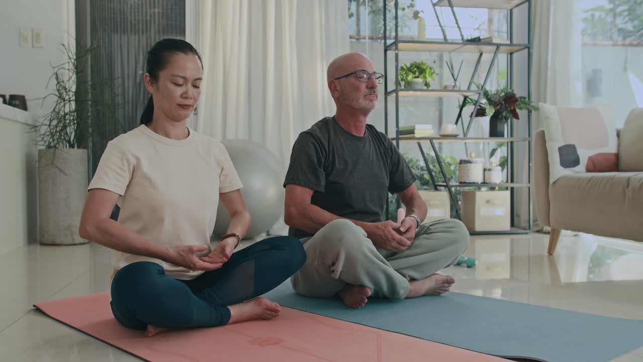 Spouses Sitting in Lotus Pose and Practicing Breathing Exercises
